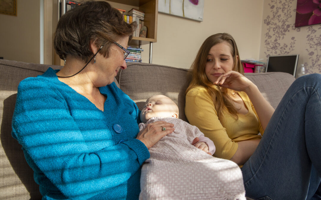 Home Start volunteer holding a baby